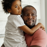 father holding child in kitchen