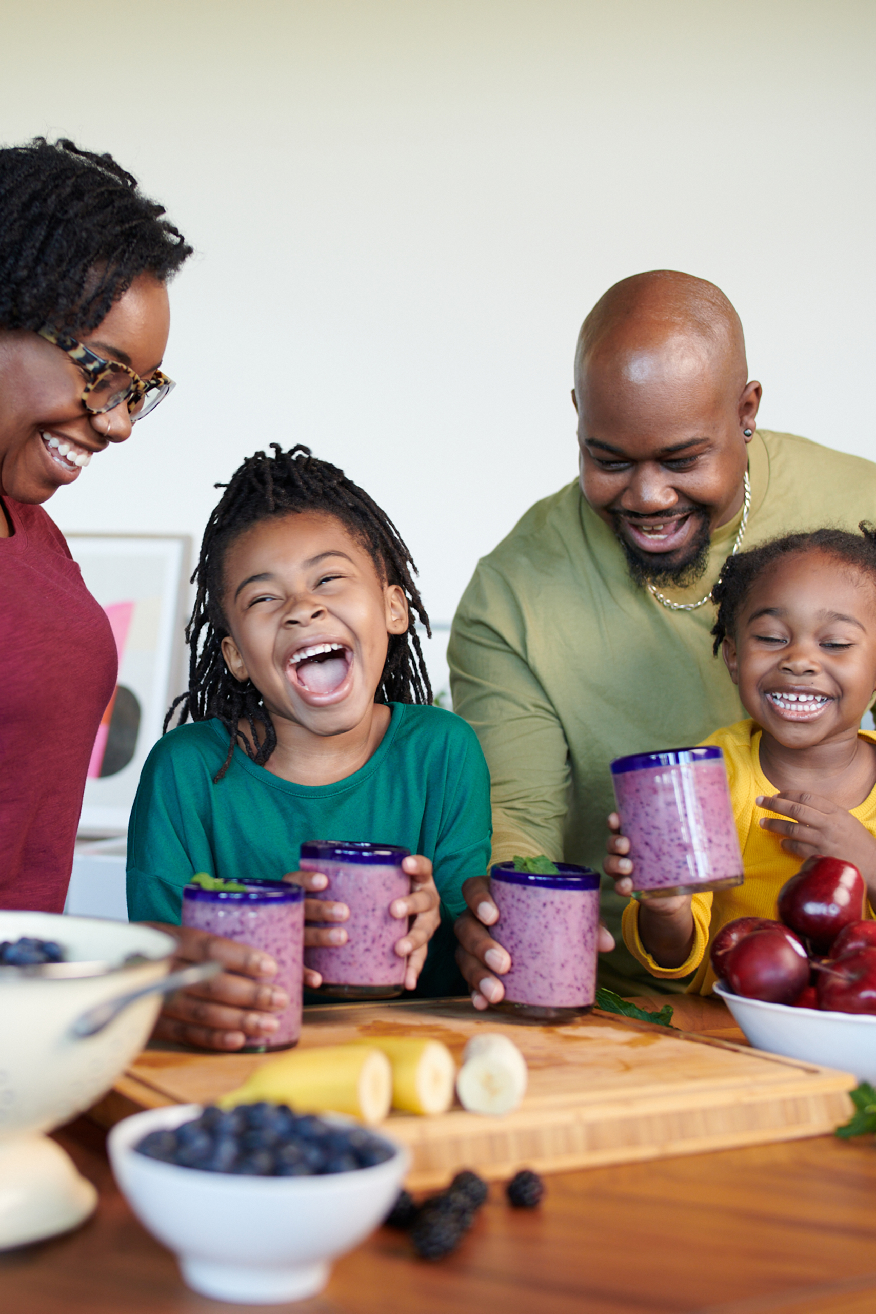 mom-and-dad-with-two-daughters-drinking-blueberry-shakes