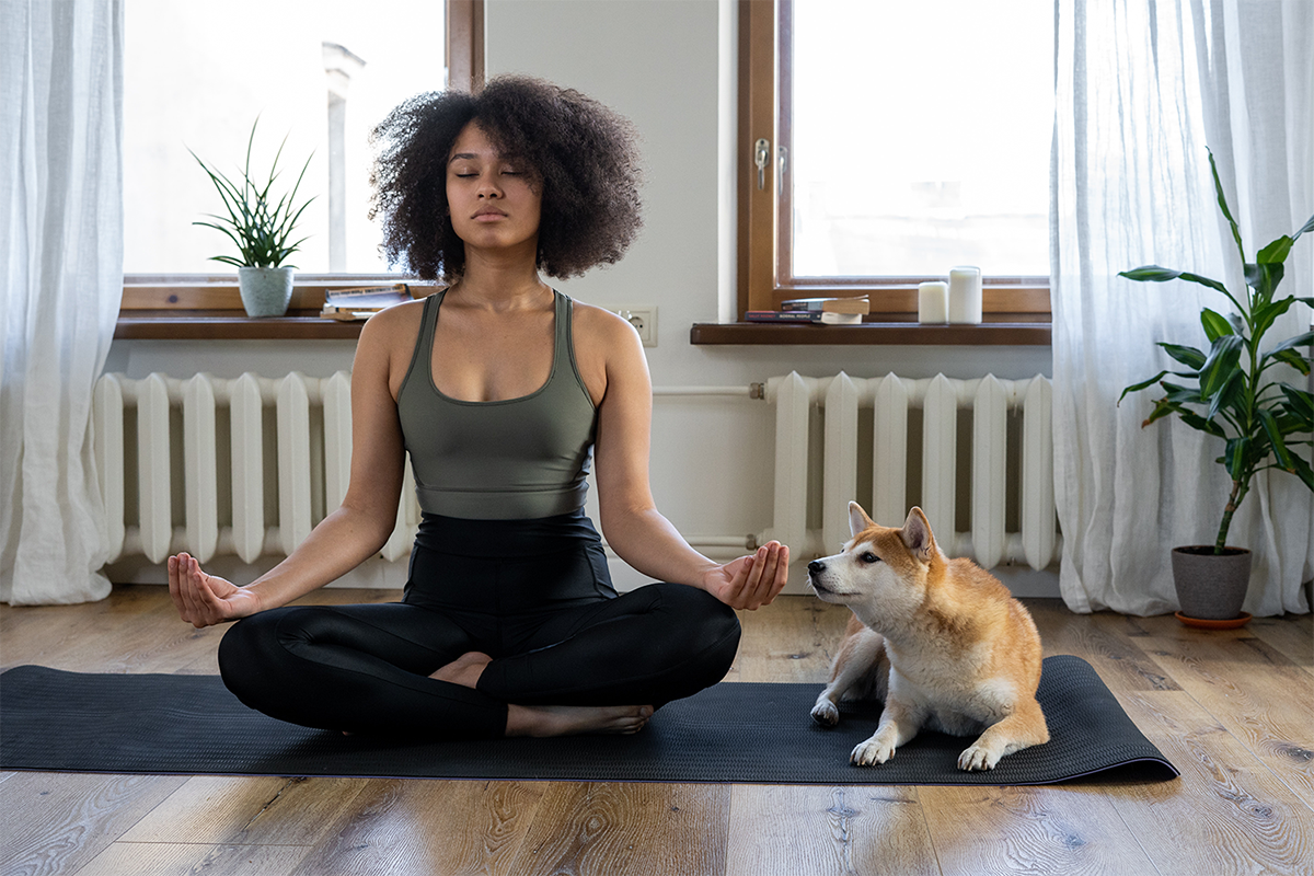 Young woman meditating with her dog