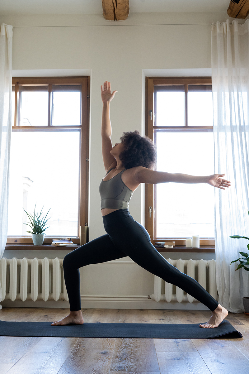 woman practicing yoga in her living room